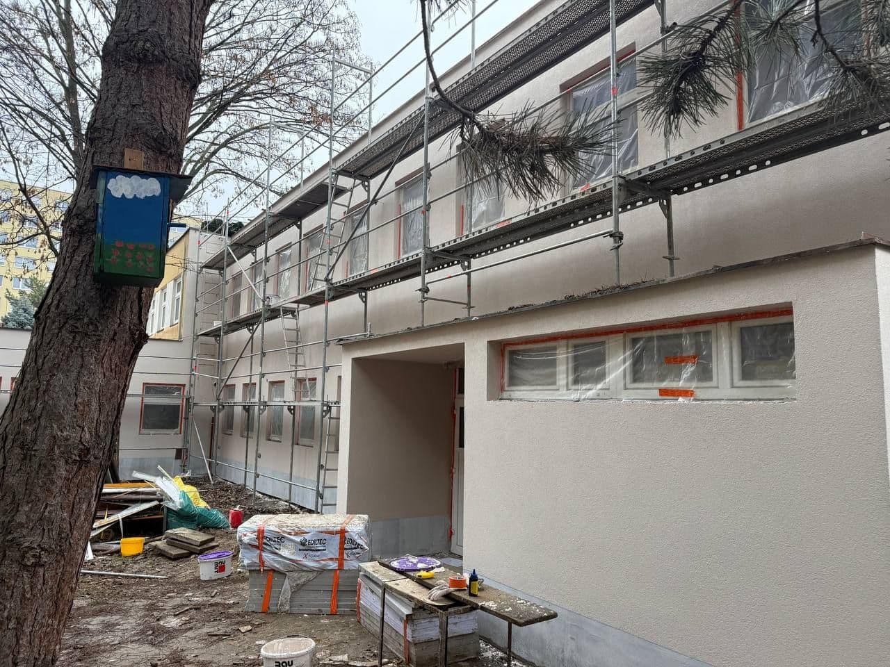 Detail dokončené fasády v úrovni ochozu a pásových oken.