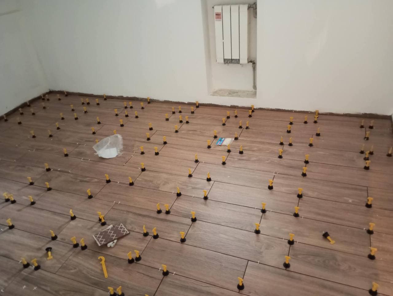 Pokládka dřevodekorové dlažby s distančními a nivelačními prvky.