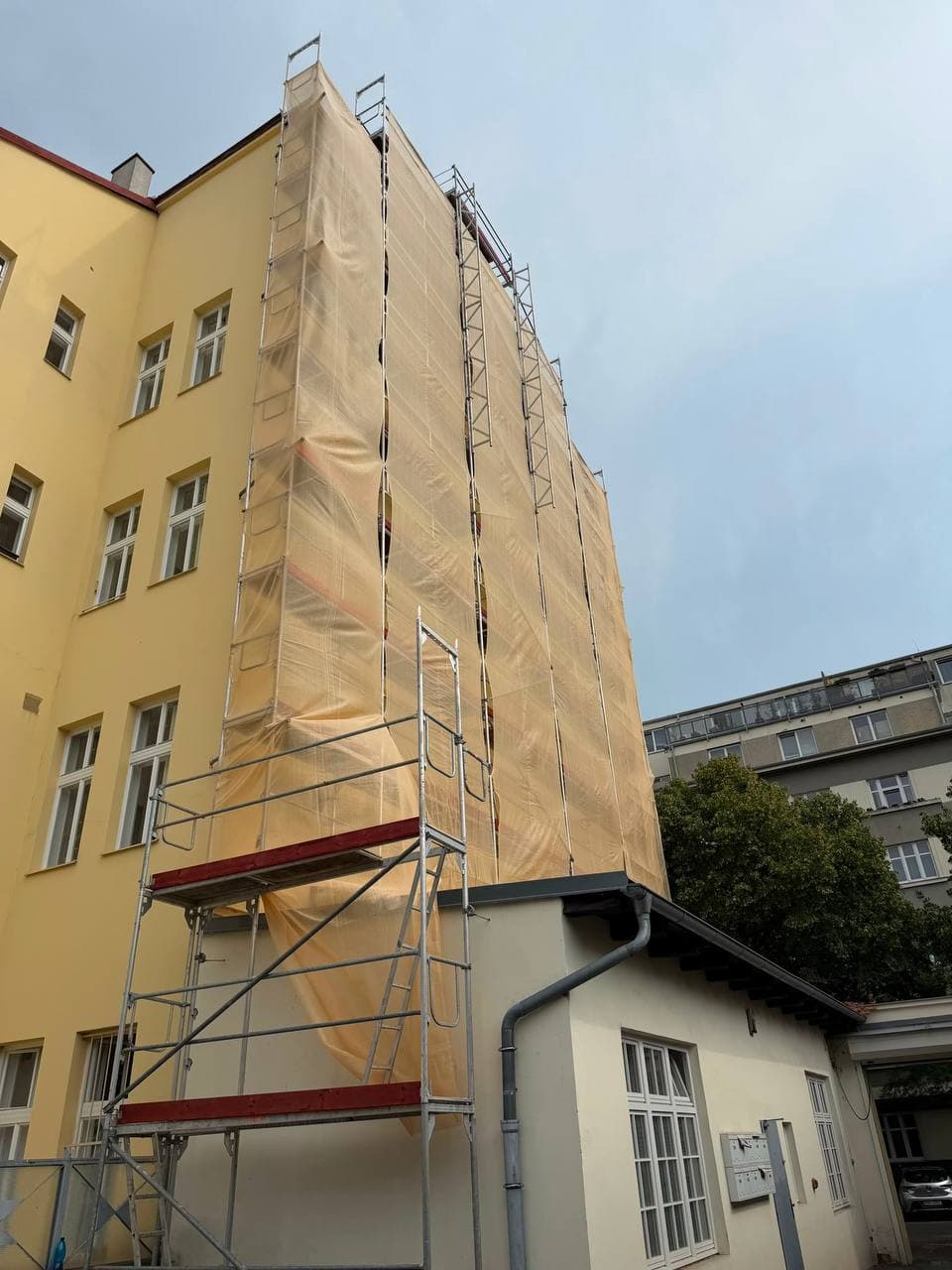 Lešení u štítové stěny během stavebních prací.