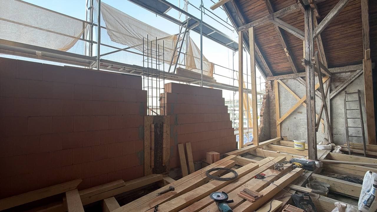 Nově vyzděná část štítové stěny mezi prvky krovu.