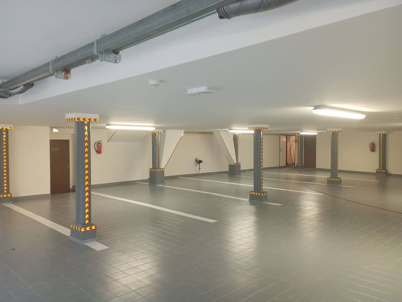 Nové světlé nátěry a parkovací stání v podzemních garážích.
