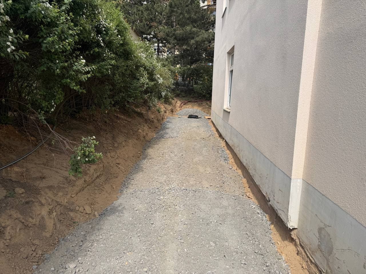 Příprava podkladu pro nový chodník kolem školy.